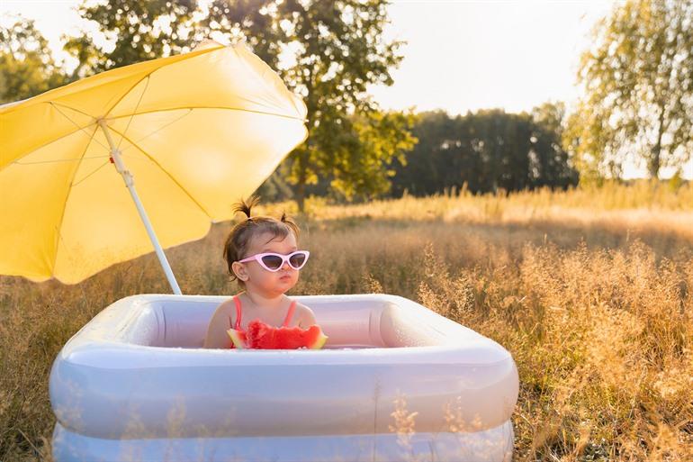 Kleinkind im flachen Kinderbecken