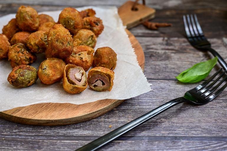 Oliven aus Ascoli probieren, entkernen und mit Fleisch gefüllte, paniert und fritierte Oliven