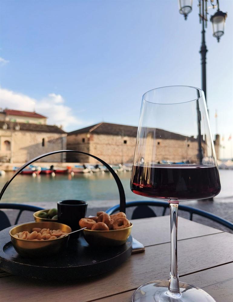 Bei einem Drink die Aussicht auf den Hafen von Lazise genießen